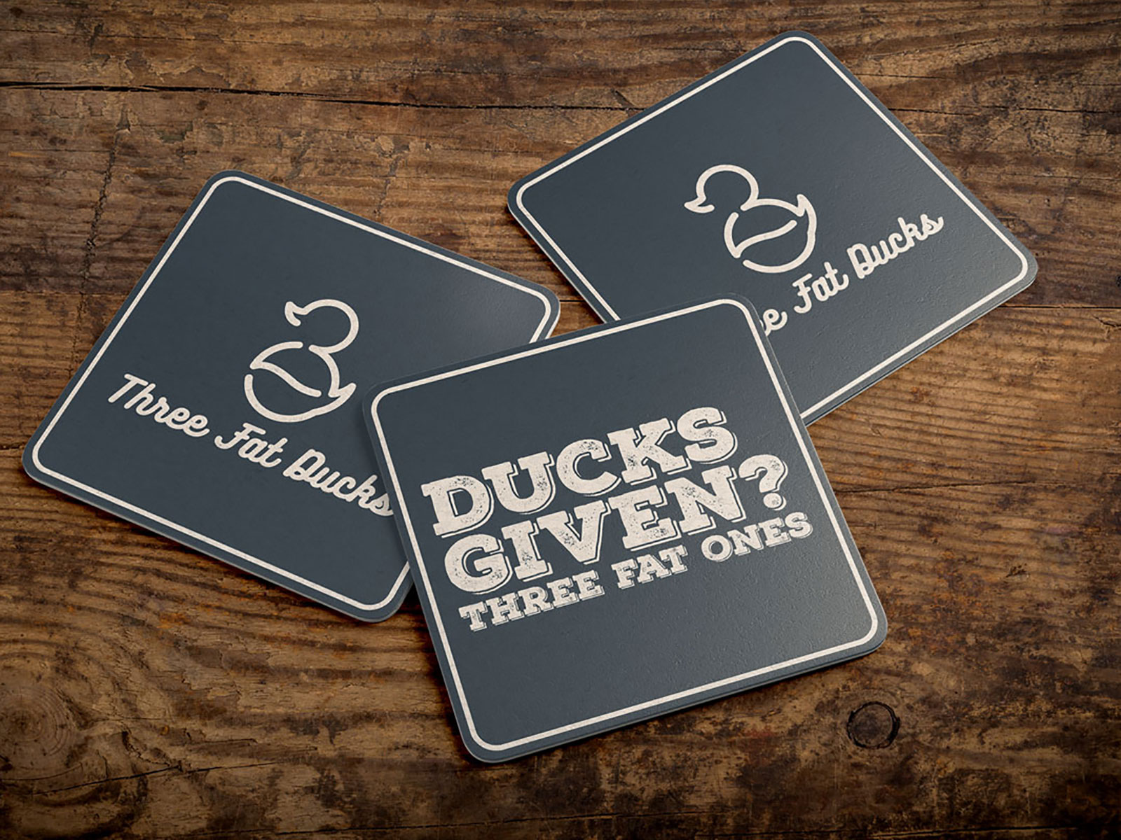Three Fat Ducks coasters on wooden table